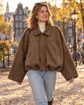 Vrouw in bruine suède-look jas met kraag in de stad