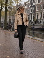 Korte trenchcoat dames in khaki, gedragen in een Amsterdamse straat